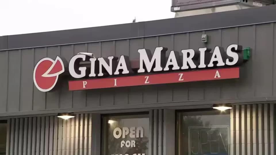 Gina Maria's Pizza restaurant exterior with illuminated signage on storefront in Minneapolis area