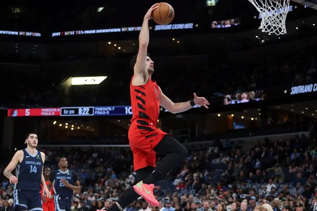 Memphis Grizzlies player finishing a fast-break dunk against the Trail Blazers