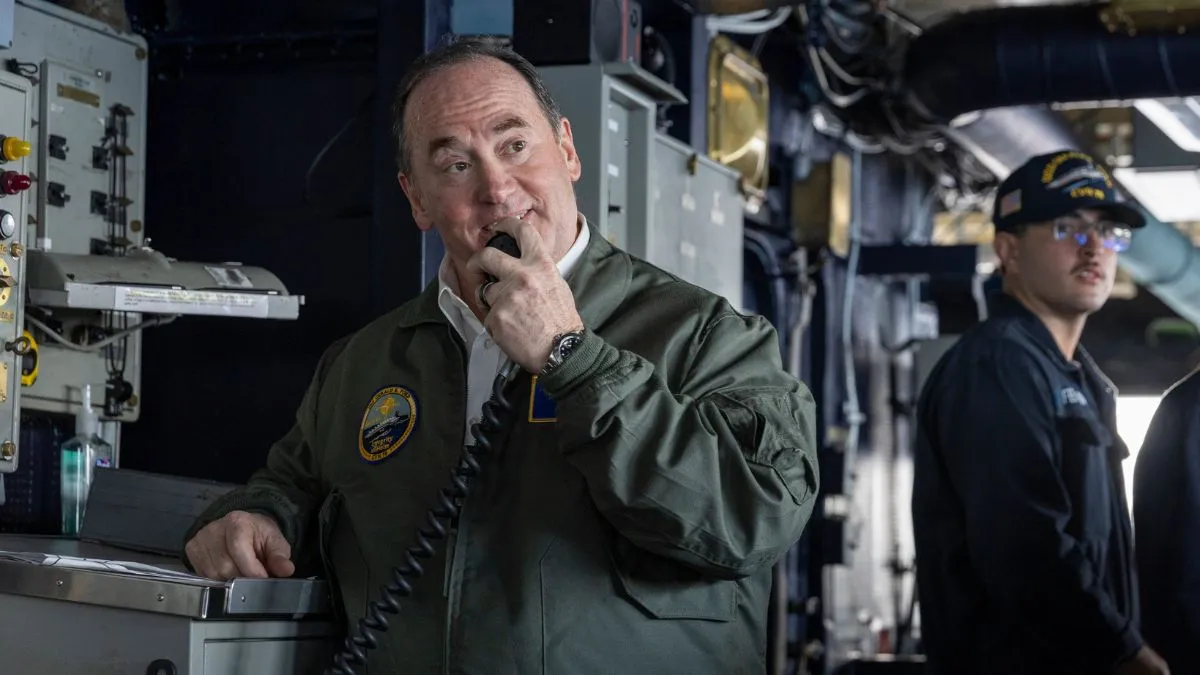 US Navy Secretary John Phelan communicating aboard a naval vessel amid active US Navy operations linked to Iran conflict