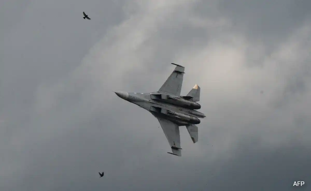Military fighter jet performing a high-speed maneuver in cloudy skies during an aerial operation