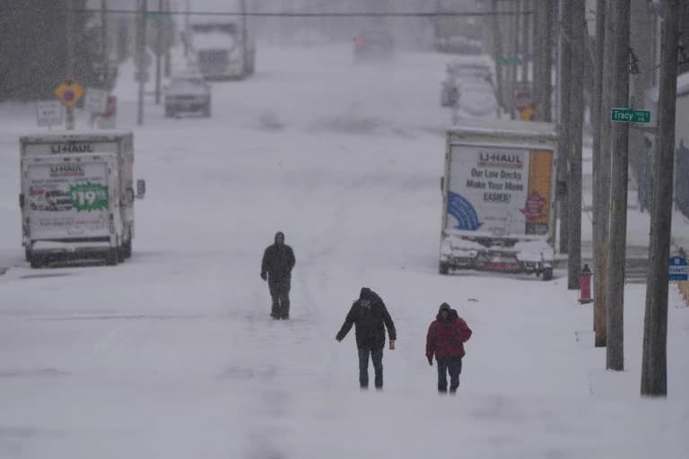 People walking on snow-covered street during severe US winter storm