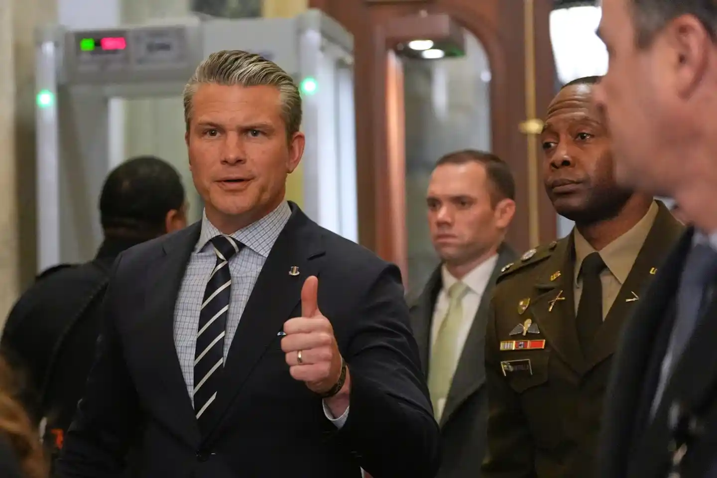 A U.S. official gestures while speaking with reporters inside the Capitol.
